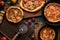 Vegetarian rustic pizzas. Homemade tomato and mushroom pizzas in cast iron pans and oak boards on dark background top view