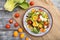 Vegetarian salad of pac choi cabbage, kiwi, tomatoes, kumquat, microgreen sprouts on gray wooden background. Top view, close up