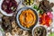 Vegetarian snack table. Pumpkin, beets hummus, beans and mushroom pate, vegetables, nuts, bread on a stone table, top view.