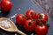 Vegetarian still life with fresh grape tomatoes, pepper and salt in wooden spoon on wooden background, selective focus