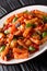 Vegetarian Tortiglioni pasta with vegetables and basil in tomato sauce close-up in a plate. vertical