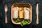 Vegetarian tortilla wraps in paper plate and wooden cutlery on dark background, top view, close up. Healthy lunch snack
