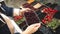 Vegetarian woman chooses cornelian cherry in the supermarket.