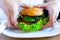 Veggie burger healthy vegan food. Salad, avocado, vegetable on vegetarian hamburger eating cute woman. Vegan sandwich