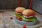 Veggie burgers with a chop of eggplant, lettuce, pickled onions, tomato on a brown wooden background.