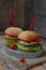 Veggie burgers with a chop of eggplant, lettuce, pickled onions, tomato on a brown wooden background.