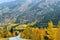 Vehicle on a curvy road with trees in beautiful fall foliage