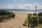 Vehicle Entrance onto Beach Lined with Green Plants