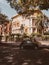 Vehicle parked by a building on a tree-lined street