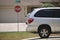 Vehicle parked in front of wide garage double door on paved driveway of typical contemporary american home