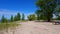 Vehicle Parking Lot Along Sunny Beautiful Beach Sand in Summer.  Warm Sunshine Beach Shoreline Next to Public Car Lot