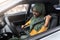 Vehicle Safety. Young Black Muslim Lady In Hijab Fastening Seatbelt In Car