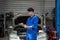 Vehicle service maintenance asian man checking under car condition in garage. Automotive mechanic maintenance checklist