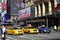 Vehicle yellow taxi cars stopping for traffic light pedestrian crossing in front of Hotel Pennsylvania Midtown Manhattan, New York
