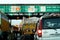 Vehicles, cars, trucks queue at a toll booth in India for cash or fastag based payment