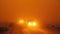 Vehicles cautiously navigating a road during a dust storm, with headlights barely piercing through the thick dust