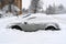 Vehicles covered with snow in the winter blizzard