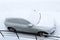 Vehicles covered with snow in the winter blizzard in the parking lot