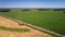 Vehicles drive along rural road past wheat farmland