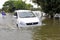 Vehicles pass through the flooded roads