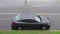 Vehicles Splash Rainwater on an Over a Parked Car During a Storm