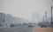 Vehicles traveling on the road amidst heavy smog.