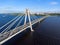 Vehicular cable-stayed bridge with vehicle flows on road lanes. Aerial view at the riverbank and part of carriageway. Cherepovets,