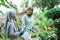 Veiled mother and daughter caring for ornamental plants in garden