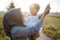 Veiled mother plays while holding her daughter while standing against the background of the shining sky