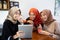 Veiled young women relaxing with chatting and joking using digital tablet