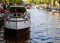 Veiw on the bridge through the river channel with boat, typical picture of canals in Amsterdam