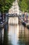 Veiw on the bridge through the river channel with boat, typical picture of canals in Amsterdam