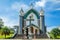 Velankanni Matha catholic church facade with cross, palms and stairs in foreground, Nedumkandom, Kerala, South India