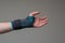 Velcro wrist stabilizer cast worn by Caucasian male hand. A blue split brace meant to aid Carpel Tunnel syndrome. Close up studio