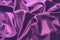 Velour fabric, similar to silk. Textiles in a folds and beautiful waves. Purple, pink, magenta shades on the drapery