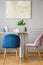 Velvet pastel pink and petrol blue chairs at small dining table in bright living room