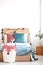 Velvet pastel pink and turquoise pillows and toy fox on single wooden bed with white bedding and blanket