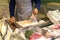 Vendor cutting fish. A typical scene at the traditional fish market