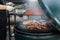 Vendor roasting tasty smoked steaks at street food festival, flipping with tongs. Chef cooking bbq