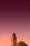 Venetian aged bell tower with cross and reddish bloody sunset, Venice, Italy, summer time