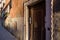 Venetian ally with wooden door, leading to a courtyard.