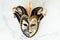 Venetian carnival mask on the white marble background. Full-head black characteristic mask with golden decoration. Flat lay. Copy