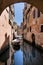 Venetian dreams: evocative image of a quiet canal from below a bridge connecting houses. Venice, Italy