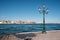 The Venetian lagoon with street lamp post on Guidecca promenade. Venice skyline with Punta della Dogana, church Santa