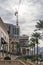 The Venetian Palazzo hotel with lush green plants and palm trees, people walking along the sidewalk and powerful clouds