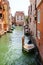 A venetian quiet channel with parked motor boats in summer day