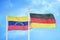 Venezuela and Germany two flags on flagpoles and blue sky