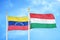 Venezuela and Hungary two flags on flagpoles and blue sky