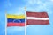 Venezuela and Latvia two flags on flagpoles and blue sky