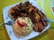 Venezuelan recipe stewed meat with spring vegetables, rice and fried plantains